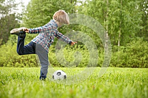 Sports Kid. Baby playing soccer ball in the park. Children play football. Family leisure