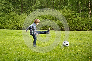 Sports Kid. Baby playing soccer ball in the park. Children play football. Family leisure