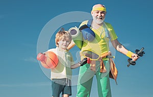 Sports for kids. Father and son sporting - family time together. Senior man and cute little boy exercising on blue sky