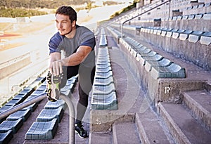 Sports, legs and man stretching in stadium for race, marathon or competition training for health. Fitness, wellness and