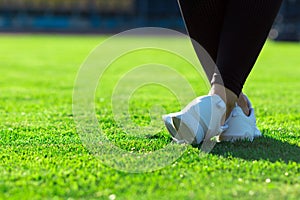 Sports Legs of young athletic woman in dark tights and light sne