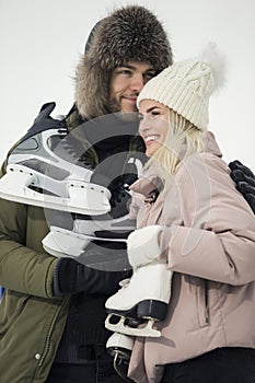 Sports and Lifestyle. Closeup of Young Loving Caucasian Couple On Skatingrink With Ice Skates Posing Together Over a Snowy Winter