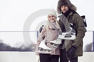 Sports and Lifestyle. Young Caucasian Couple On Skatingrink With Ice Skates Posing Together Over a Snowy Winter Landscape Outdoor