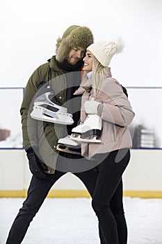 Sports and Lifestyle. Young Loving  Caucasian Couple On Skatingrink With Ice Skates Posing Together Embraced Over a Snowy Winter