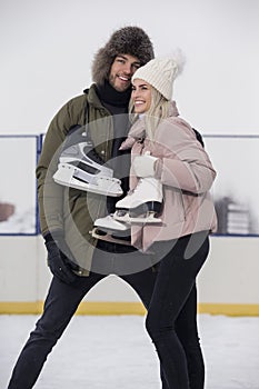 Sports and Lifestyle. Young Loving Caucasian Couple On Skatingrink With Ice Skates Posing Together Over a Snowy Winter Landscape