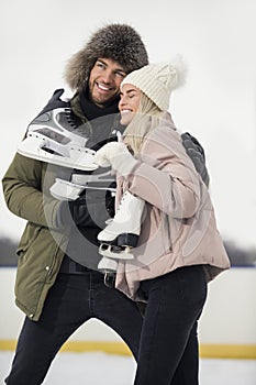 Sports and Lifestyle. Young Loving Caucasian Couple On Skatingrink With Ice Skates Posing Together Over a Snowy Winter Landscape