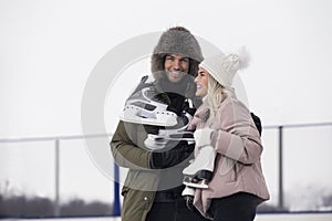 Sports and Lifestyle. Young Loving Caucasian Couple On Skatingrink With Ice Skates Posing Together Over a Snowy Winter Landscape