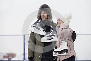 Sports and Lifestyle. Young Loving Caucasian Couple On Skatingrink With Ice Skates Posing Together Over a Snowy Winter Landscape