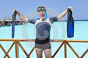 Sports man in equipment for a snorkeling on sundeck shows a hand in the sea. Maldives