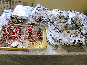 Sports medals and gifts of the heroes on the table. Medals for victory, champion, gold, silver and bronze medals