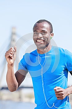 Sports and music. Young african decsent men jogging and listening to the MP3 player