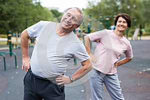 Sports pensioners do a warm-up on outdoor sports ground