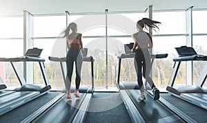 Sports people running on treadmills, looking out the window