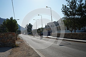 Cyclists ride along the Eparchiaki Odos Lardou-Lindou highway in August. Lardos, Rhodes Island, Greece photo