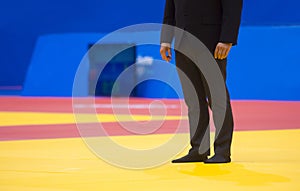 Sports referee on a yellow wrestling carpet in the gym