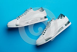 Sports shoes. View from above. Women's new sneakers on a blue background, top view. Sneakers isolated on blue