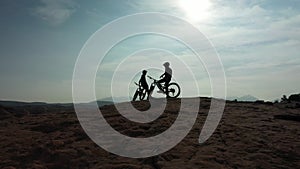 Sports, silhouette and people on mountain bike break during outdoor ride, desert journey or off road cycling. Relax