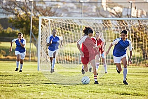 Sports team, girl soccer and kick ball on field in a tournament. Football, competition and athletic female teen group