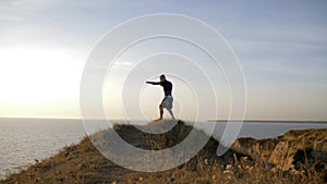 Sports training on open air, muscular pugilist male practicing boxer punches before sparring on workout on hill near sea