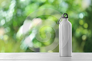 Sports water bottle on table against blurred background