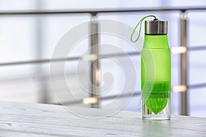 Sports water bottle on table against blurred background.