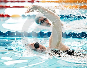 Sports, water splash or people training in swimming pool in a race competition, exercise or cardio workout. Swimmer