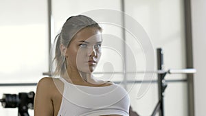 Sports woman pulling weight on fitnes equipment in sports club interior