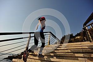 Sports woman running up on stone stairs