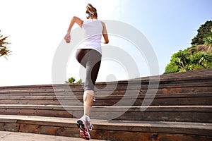 Sports woman running up on wooden stairs