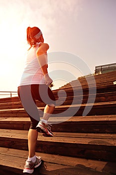 Sports woman running up on wooden stairs