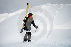 sports woman skier climbs uphill to the top to quickly go down the mountain, off the track, dangerous winter sport
