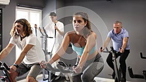 Sports woman warming up on bikes in spin class at gym