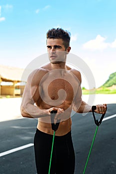Sports Workout. Fitness Muscular Man Model Doing Expander Exercises