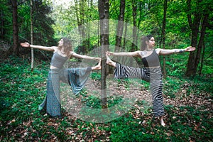 Sports yoga pose with planes practiced by couple of girl friends photo