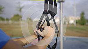 Sportsman assemble a TRX workout fitness to exercises in city park