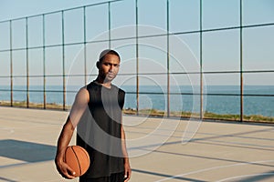 Sportsman with basketball ball on sports court