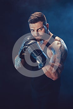 Sportsman boxer fighting on black background with shadow. Copy Space. Boxing sport concept.