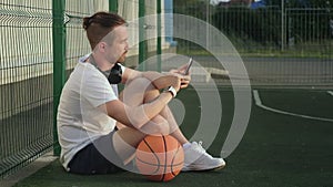 Sportsman browsing news in mobile phone during break time in basketball