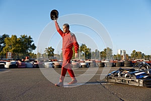 Sportsman celebrating end of go-cart racing at outdoor driveway