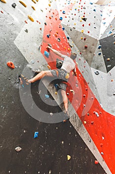 Atleta alpinista toccante su sul ripido la roccia sul artificiale parete dentro. estremo gli sport un 