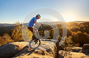 Sportsman cyclist balancing on back wheel on trial bicycle