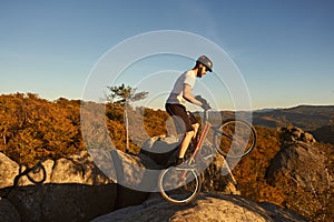 Sportsman cyclist balancing on back wheel on trial bicycle