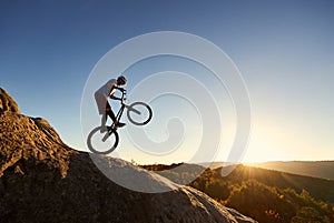 Sportsman cyclist balancing on back wheel on trial bicycle