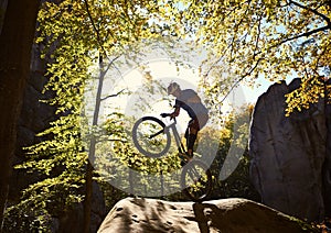 Sportsman cyclist balancing on back wheel on trial bicycle