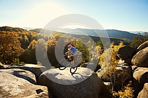 Sportsman cyclist balancing on back wheel on trial bicycle