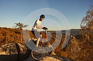 Sportsman cyclist balancing on back wheel on trial bicycle