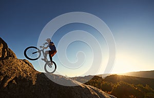 Sportsman cyclist balancing on back wheel on trial bicycle