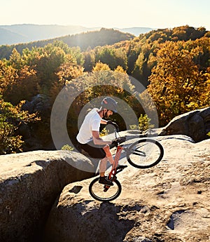 Sportsman cyclist balancing on back wheel on trial bicycle