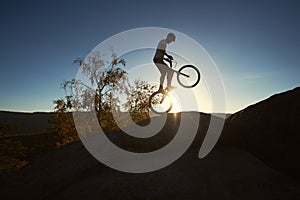 Sportsman cyclist balancing on back wheel on trial bicycle