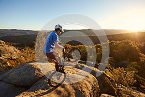 Sportsman cyclist balancing on back wheel on trial bicycle